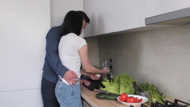 A fiatal pár friss zöldségeket mos egy modern konyhában. — Stock videók