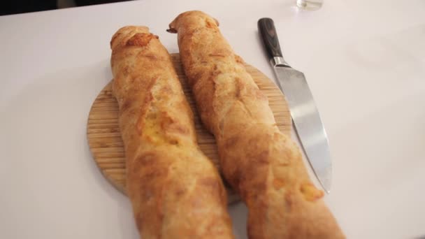 Two delicious baguettes on the white kitchen table. — Stock Video