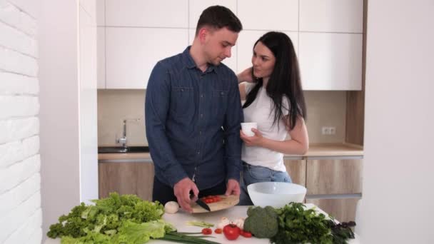 Le mari prépare une salade végétarienne pour sa femme bien-aimée . — Video
