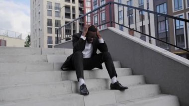 Merdivenlerde oturan Afro-Amerikalı, New York 2020 'deki durum için endişeleniyor. George Floyd' un ölümü üzerine New York 'u yağmalayıp ayaklandırıyor..