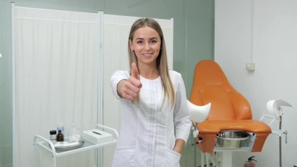 A pretty gynecologist shows a thumbs up in a beauty clinic. — Stock Video