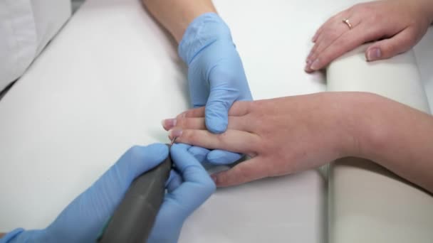 Vista de cerca del podólogo femenino hace una manicura de hardware en una clínica de cosmetología . — Vídeo de stock