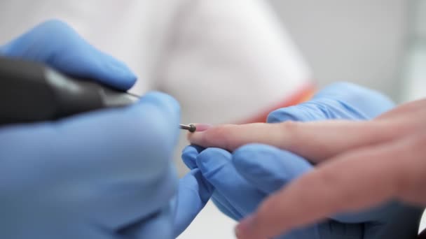 Vista de cerca del podólogo femenino hace una manicura terapéutica en una clínica de cosmetología . — Vídeo de stock