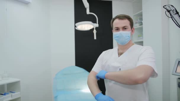 Male handsome surgeon doctor arms crossed in operating room at cosmetology clinic. — Stock Video