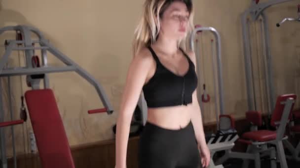 Sexy krásná dívka trénuje břišní svaly na funkční trénink, Dívka dřepí a složí ruce. — Stock video