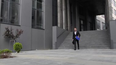 Çantası olan başarılı bir işadamı iş merkezinden ayrılır ve başarılı bir anlaşmanın başarısı ile bir şirket çalışanını memnun eder..