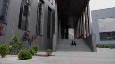 Başarısız bir projenin krizinden sonra merdivenlerde oturan ve kafasını tutan sakallı bir iş adamı..