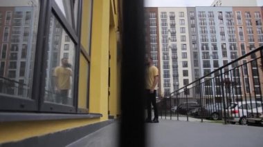 Çevrimiçi Gıda Alışverişi. Sosyal mesafeli ev izolasyonu. Sarı tişörtlü kurye malları teslim ediyor..