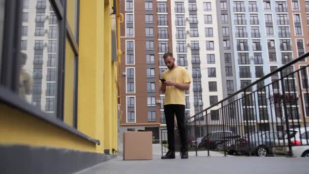 Online Food Shopping.Social afstandcing huis isolatie werk concept.De koerier in een geel T-shirt levert de goederen bellen klant. — Stockvideo