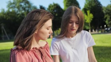 İki güzel arkadaş, modern binanın arka planındaki bir laptopta uzaktan ders çalışıyor..