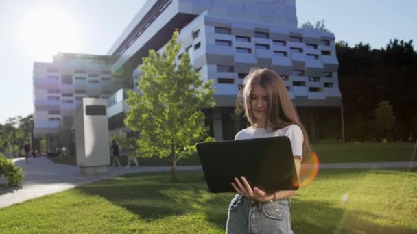 Όμορφη κοπέλα μιλάμε μέσω κάμερας στο laptop με το φίλο της σε εξωτερικούς χώρους εξ αποστάσεως μάθηση. — Αρχείο Βίντεο