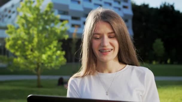 Όμορφη κοπέλα μιλάμε μέσω κάμερας στο laptop με το φίλο της σε εξωτερικούς χώρους εξ αποστάσεως μάθηση. — Αρχείο Βίντεο