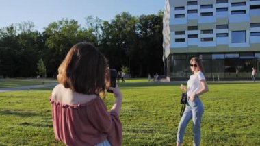 Üniversitenin arka planında iki en iyi arkadaş fotoğraf çekiyor..
