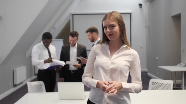 Zelfverzekerde blik van een zakenvrouw in een wit shirt in een vergaderzaal. Succesvolle vrouw, carrière, zakelijke onderhandelingen. — Stockvideo