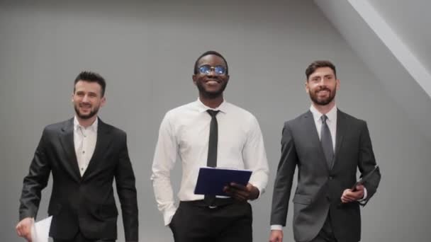 Des hommes d'affaires de groupe prospères de diverses nationalités marchant avec différents gadgets. Technologies modernes, travail d'équipe, look cool. — Video