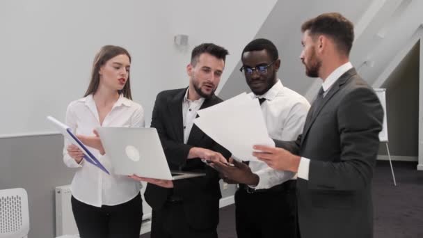 Teamwork Vier verschillende zakenmensen overwegen een nieuw project op een laptop, een groep collega 's werkt aan een marketing strategie business plan. — Stockvideo