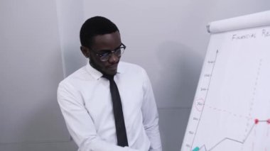 Koyu tenli Afro-Amerikan işadamı konferans odasında rapor veriyor ve şirketin kârını analiz ediyor. Takım çalışması kavramı..