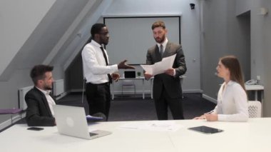 Sinirli patron, kötü iş yüzünden esmer tenli çalışanı azarlıyor. Erkek yönetmen, mali belge ekibi toplantısında hata yaptığı için beceriksiz astlarına bağırıyor..