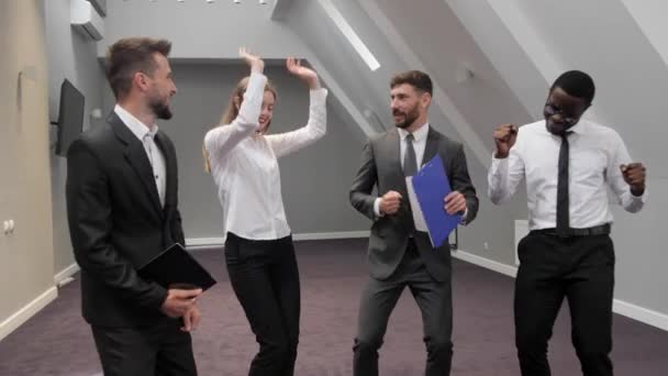 Grupo multiétnico de compañeros de trabajo bailando divertido en la sala de conferencias. Felices hombres y mujeres de negocios satisfechos con el jefe bailando para alegrar la victoria corporativa. — Vídeos de Stock