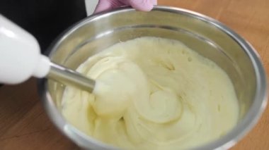 Profesyonel aşçı, pasta için kremayı elektrikli mikserle yener. Otel restoranı, mutfak, şekerleme..