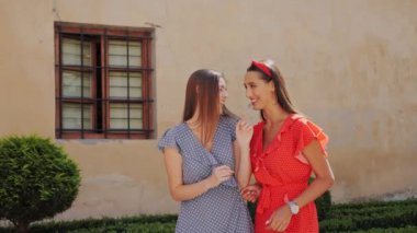 Şık giyinmiş iki güzel kız kardeş şehir sokaklarında birbirleriyle iletişim halindeler..