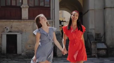 En iyi iki oyuncu arkadaş el ele tutuşuyor, gülüyor ve Avrupa 'nın eski şehrinin arka planında yürüyor..