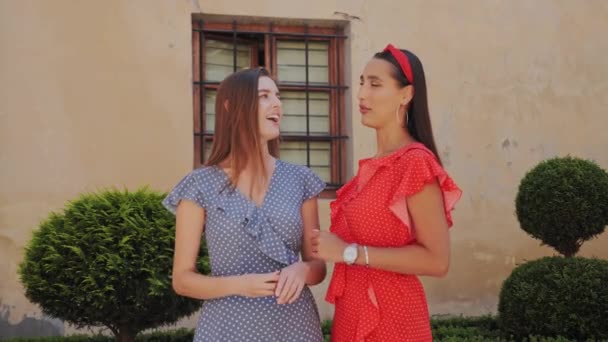 Şık giyinmiş iki güzel kız arkadaş sokak ortasında birbirleriyle iletişim kuruyor.. — Stok video