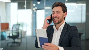 Ofisteki mutlu iş adamı bankacı elinde pasaport ve biniş kartıyla telefon görüşmeleri yapıyor. Heyecanlı erkek yolculuğunu dört gözle bekliyor..