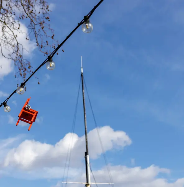 LONDON, UK - MARCH 11 : Red chair hanging from an electricty cab — Stock Photo, Image