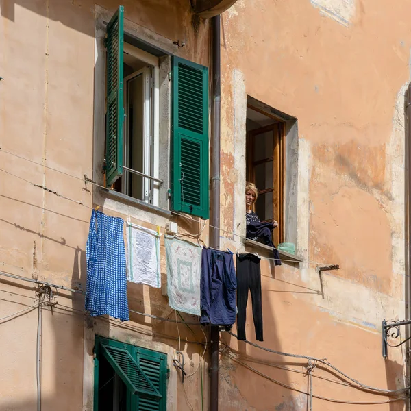 MONTEROSSO, LIGURIA/ITALY  - APRIL 22 : Woman hanging out the wa — Stock Photo, Image