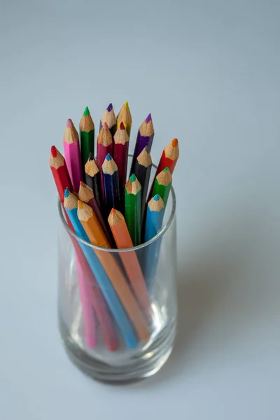 Un groupe de crayons de couleur dans un gobelet en verre — Photo