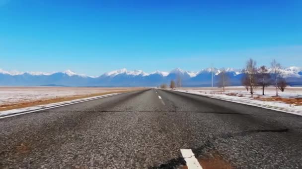 Camino recto viaje rápido viaje de invierno. Fondo montañas cielo azul 4K . — Vídeos de Stock