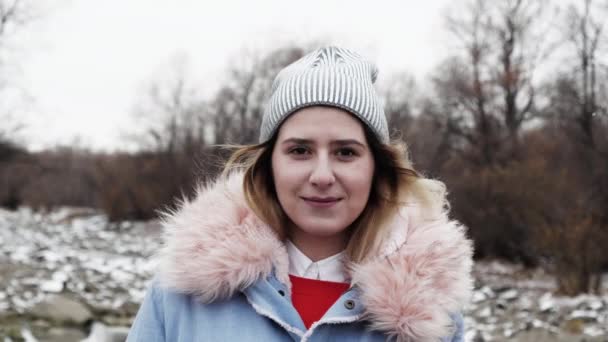 Портрет женщина улыбается лицо глядя на камеру в шляпе с морозным северным ветром 4K . — стоковое видео