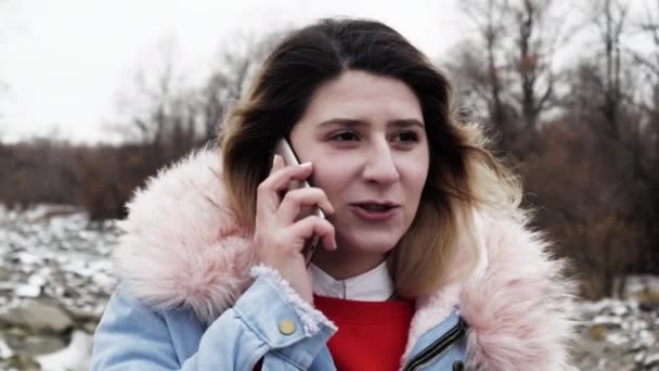 Donna attraente che parla al telefono inverno foresta settentrionale. Ragazza parla cellulare 4K. — Video Stock