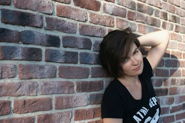 Portrait of a young woman on a brick wall background