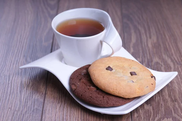 Tasse Tee Mit Weißen Und Dunklen Schokoladenkeksen Auf Welligem Teller — Stockfoto