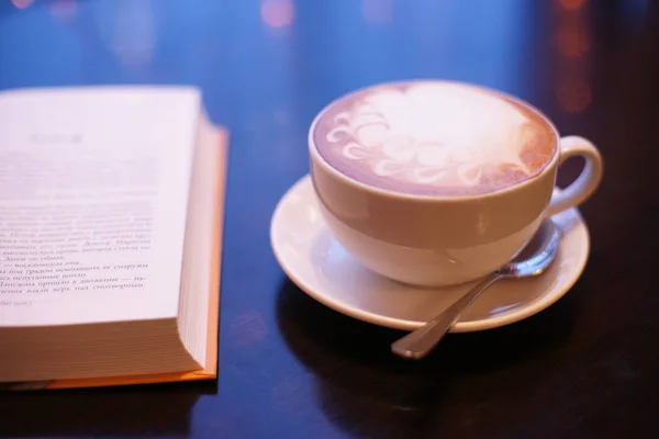 hot coffee with a book on on table