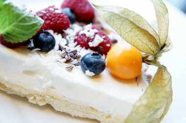 Beyaz tabakta taze meyveli cheesecake.