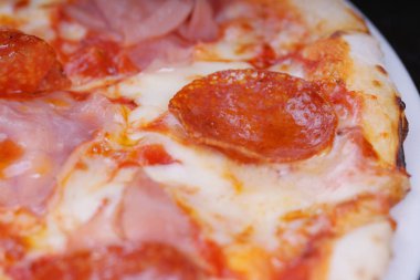 Domates soslu et pizzası ve beyaz tabakta peynir. 