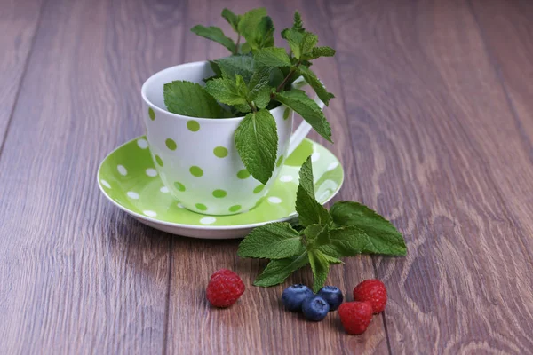 Taza Punteada Verde Con Menta Arándanos Frambuesas Sobre Fondo Madera — Foto de Stock