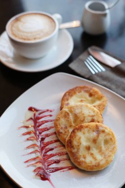 Kahveyle kahvaltı ve ahşap bir masada süzme peynirli krep.