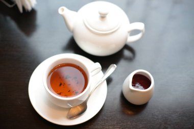 Çay fincanı ve çaydanlık siyah arkaplanda. 