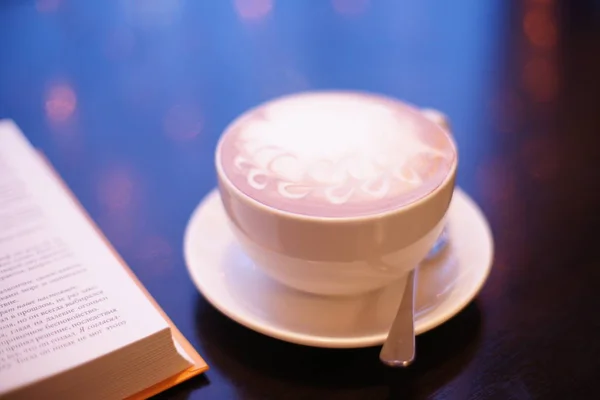 hot coffee with a book on on table