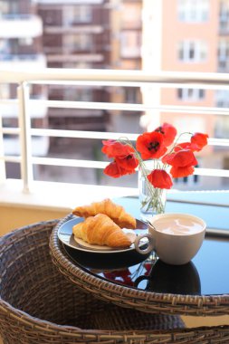 kahve fincanı ile bir tabakta kruvasan