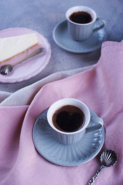 Cheesecake, sade kahve ve küçük bir fincan.