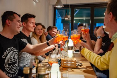 Venezia, İtalya, 22.4.2019: Bir grup arkadaş restoranda aperol spritz ile tezahürat yapıyor. İtalyan şarap bazlı kokteyl.