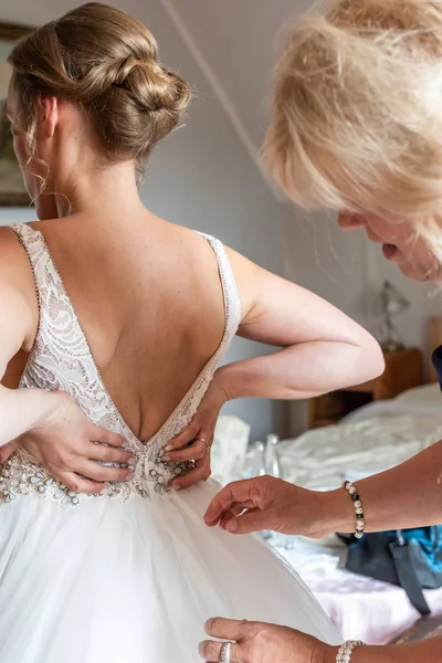 Maminka pomáhá nevěstě s oblékáním — Stock fotografie