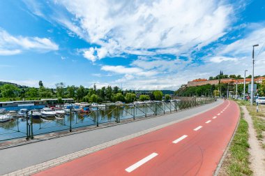 Prag'da Vltava Nehri'nin yanındaki bisiklet yolu. Arka planda Vysehrad Kalesi ile Prag Yaz şehir manzarası.
