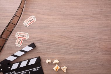 Ekipman ve sinema ahşap masa üzerinde unsurları. Film izlerken kavramı. Dikey kompozisyon. Üstten Görünüm.