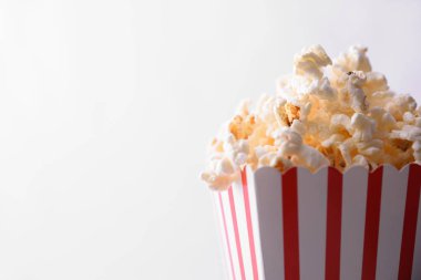 Beyaz arka plan ile karton kutu içinde patlamış mısır. Yatay kompozisyon. Önden görünüm.